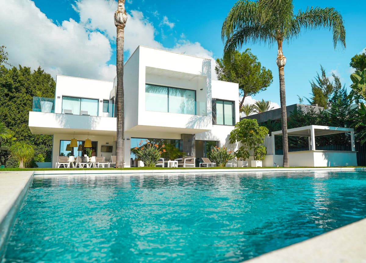 Contemporary white villa with rectangular pool and palm landscaping